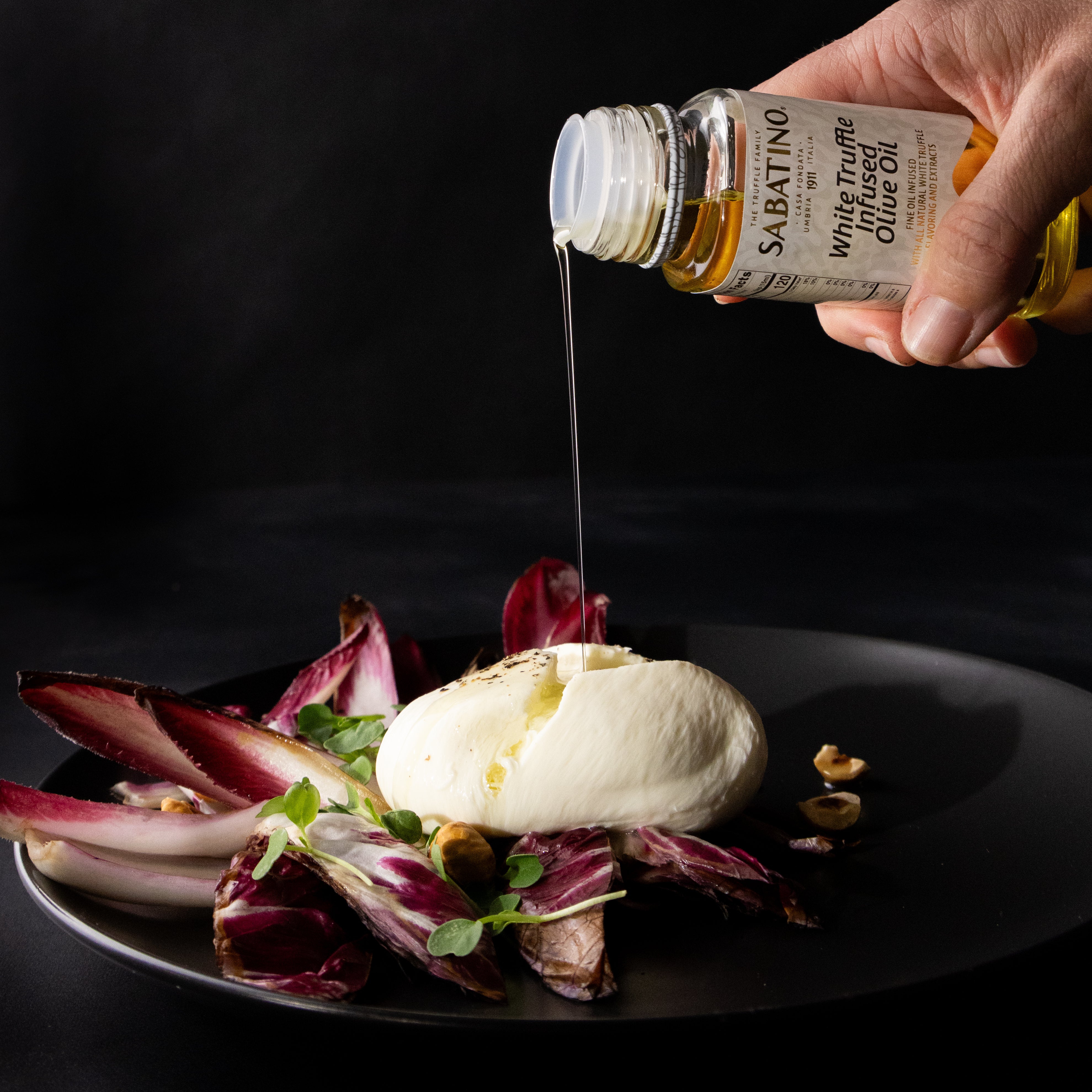 a hand pouring liquid onto a plate of food