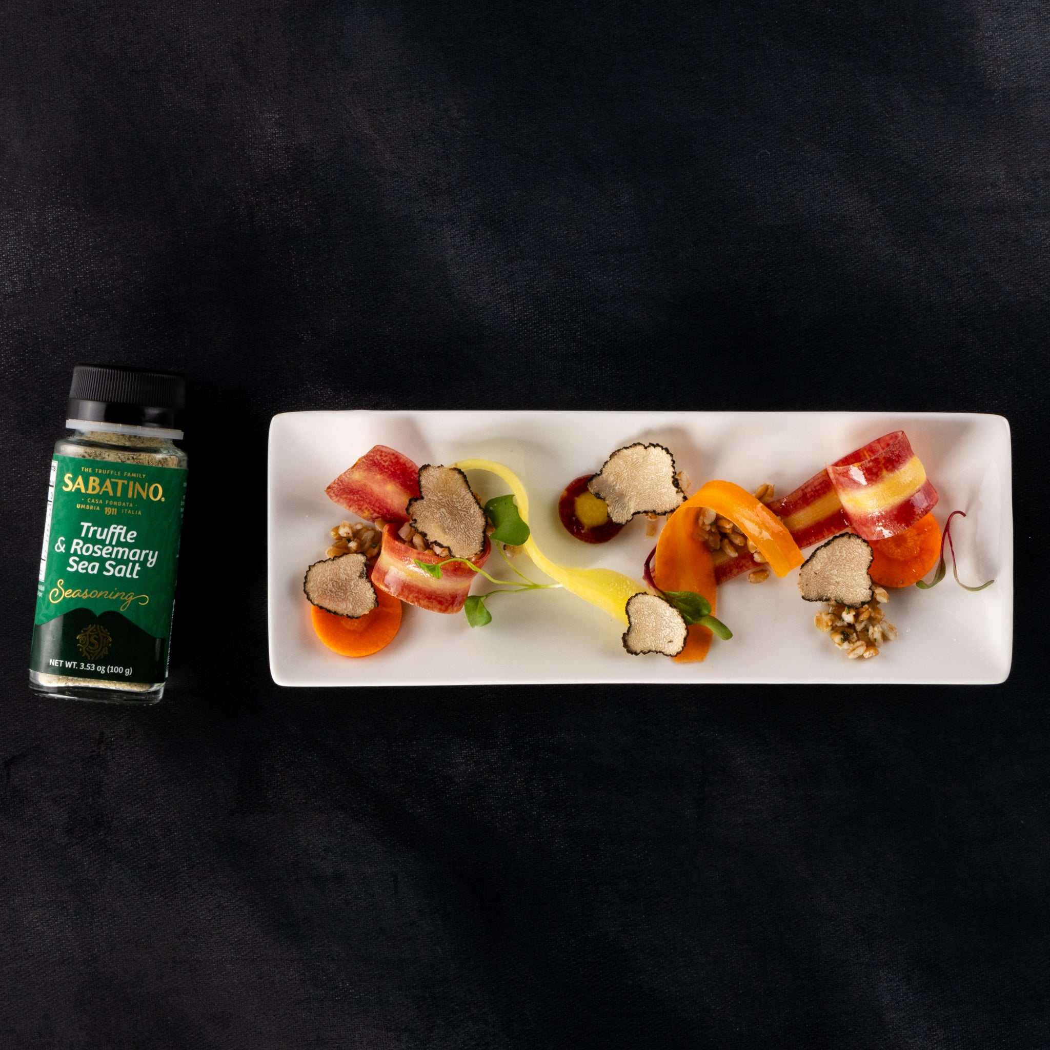 a plate of food next to a bottle of salt