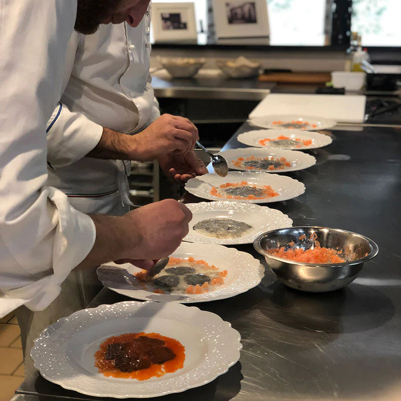 two chefs at work with truffle products on plated food