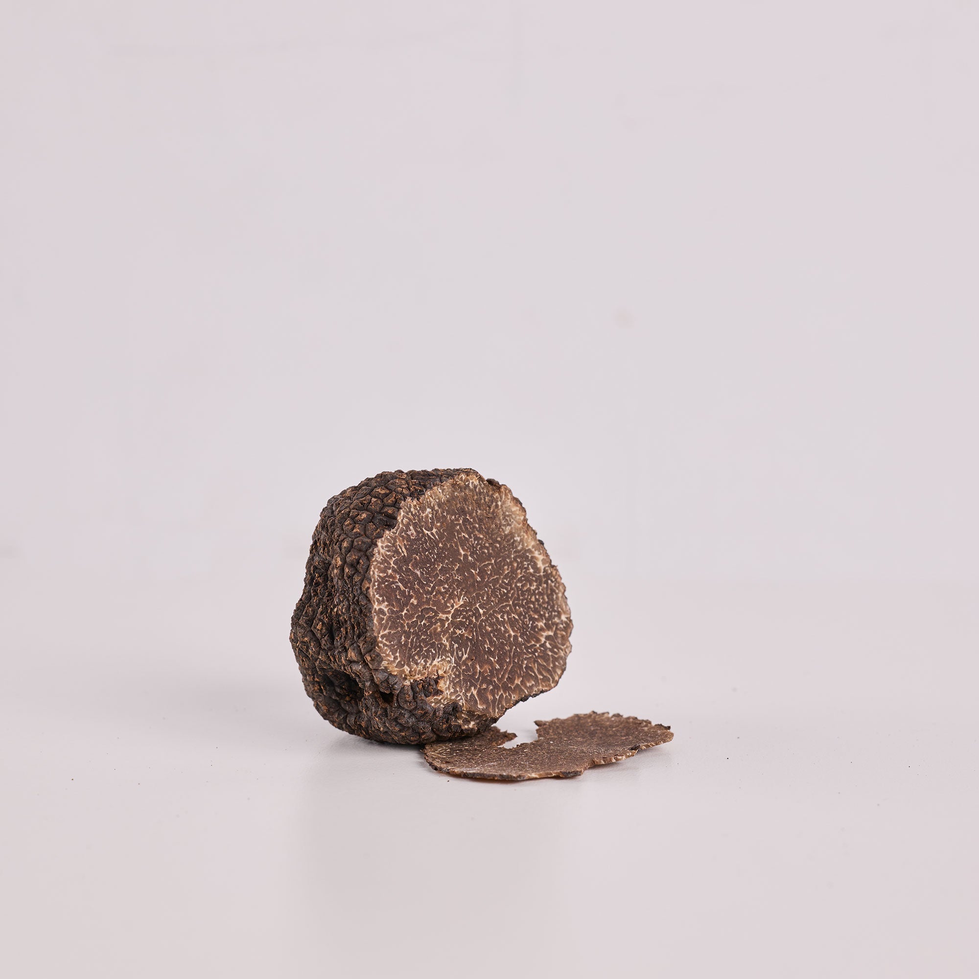 a round brown object with a round object on a white surface