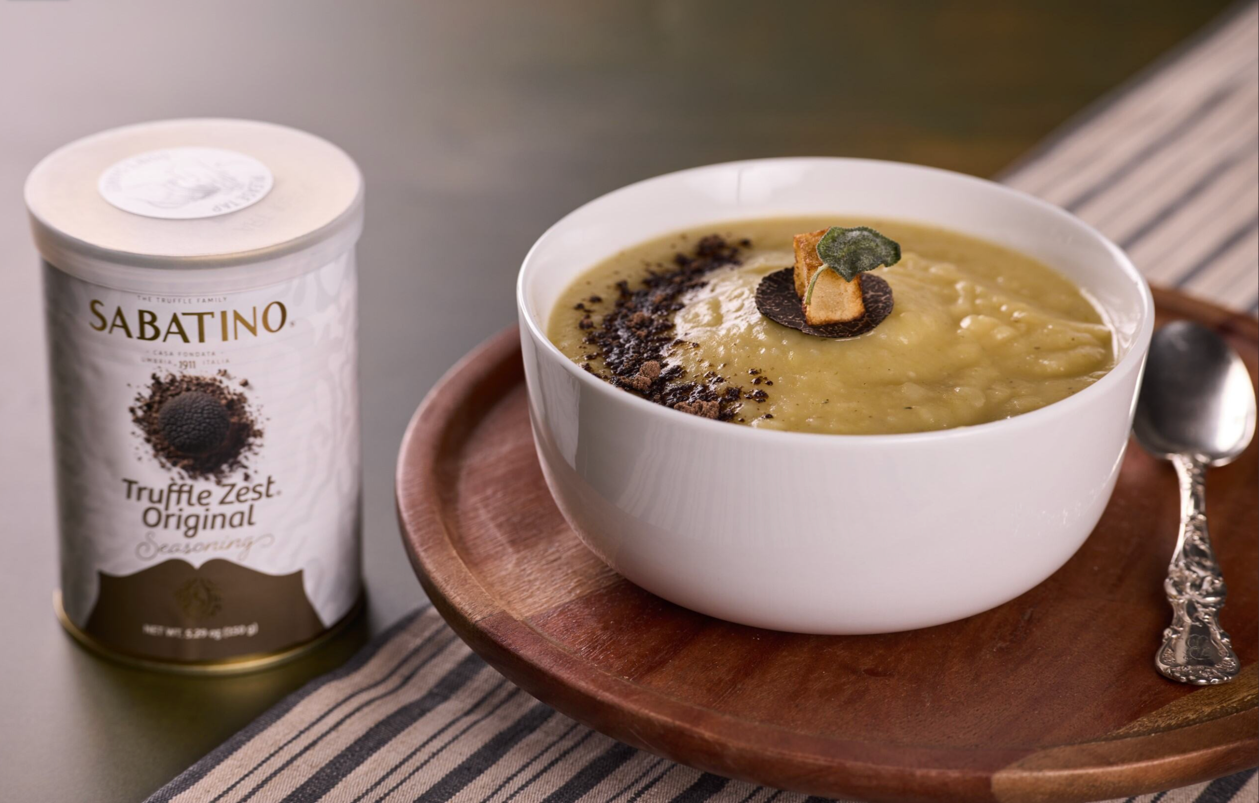 a bowl of soup on a wooden plate next to a can of yogurt