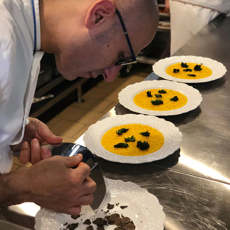 A chef at work shaving truffles over soup